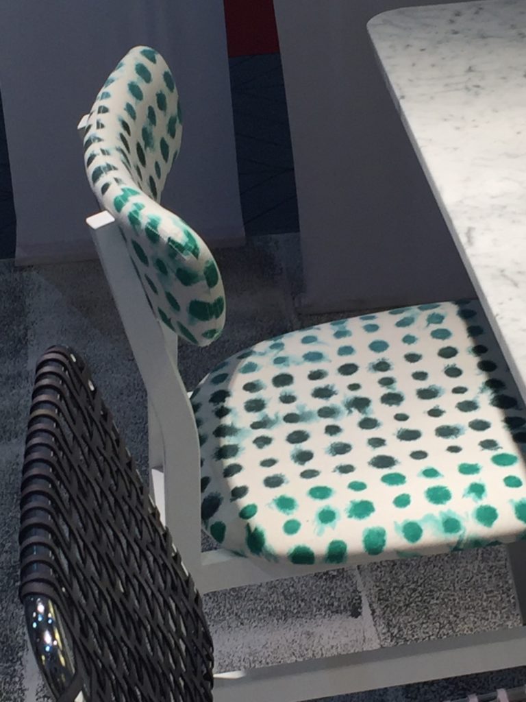 Green polka dot upholstery on a chair at a design fair.