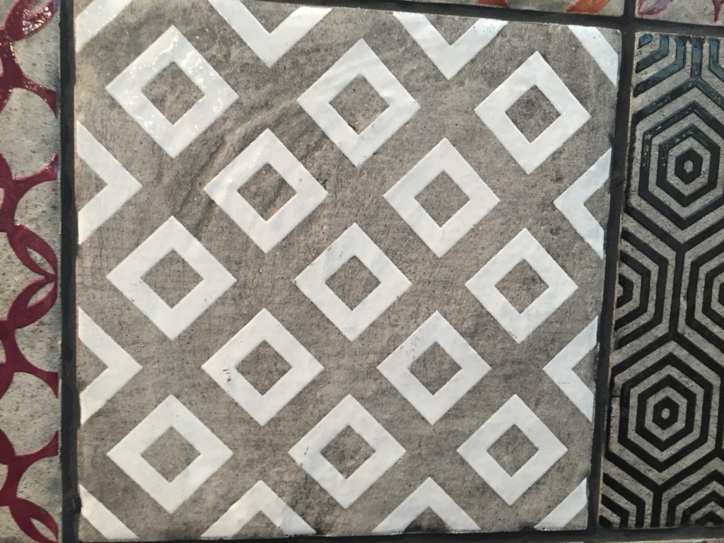 A white, geometric pattern tile.