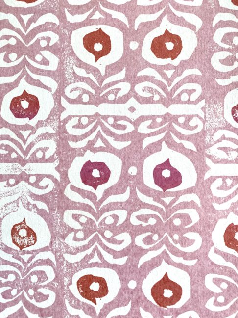 A light pink wallpaper with red and deeper pink accents, inspired by motifs on Middle Eastern ceramics.