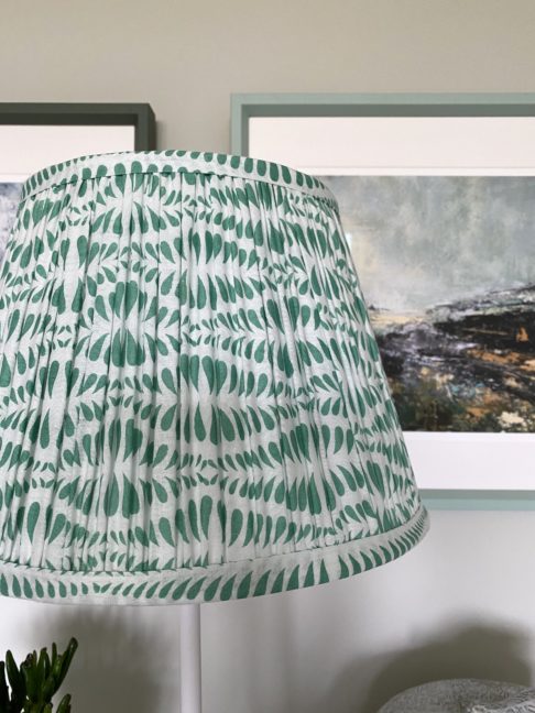 Close-up of a mint-hued small-scale block print on a patterned gathered cotton lampshade.