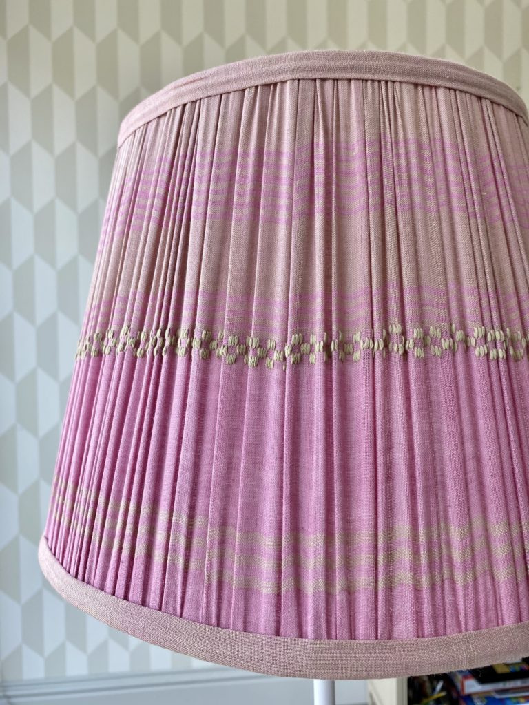 Detail of a gathered cotton, baby pink lampshade.