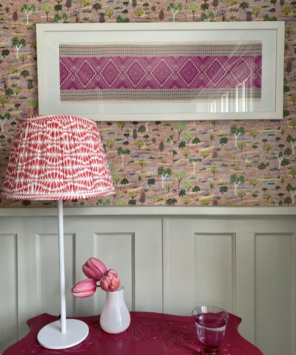 Pretty, cherry red lampshades for table lamps shown here on a pink, painted vintage table beside a four poster bed.