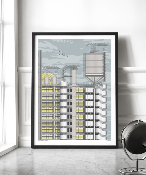 A large format print of the Lloyds building London with a slim black frame, leaned against the wall in a contemporary living space.