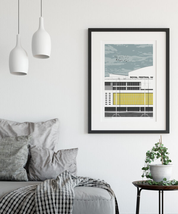 A framed artwork of the Royal Festival Hall on the wall of a contemporary sitting room space, above a side table.