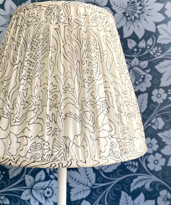 Close-up shot of a patterned, black and white, gathered silk lampshade.