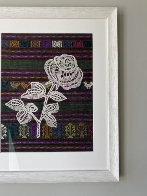 A Croatian lace rose handmade and framed in white against hand-woven Thai silk.