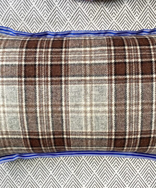 A brown wool check cushion with blue stripe trim.