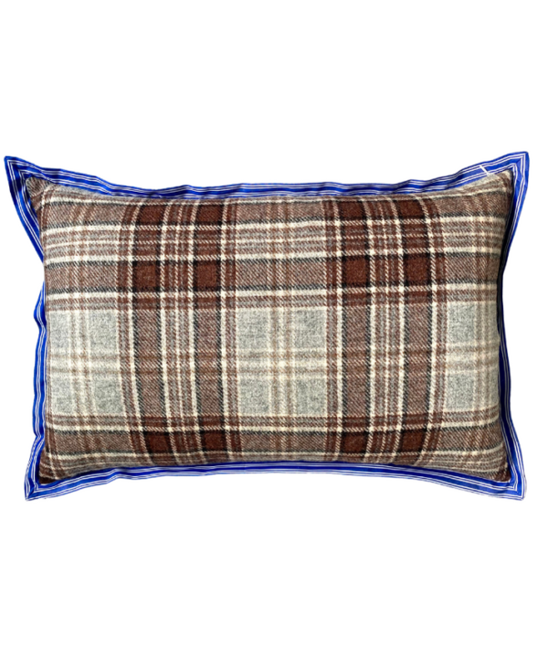 The brown woollen check reverse of a floral linen cushion with blue striped trim.