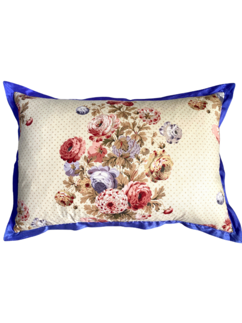 A vintage floral chintz cushion with a royal blue silk trim.