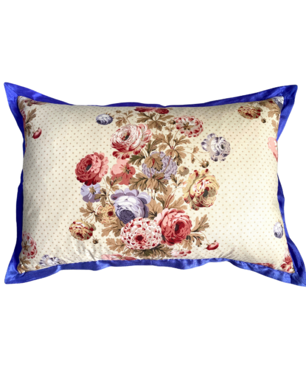 A vintage floral chintz cushion with a royal blue silk trim.