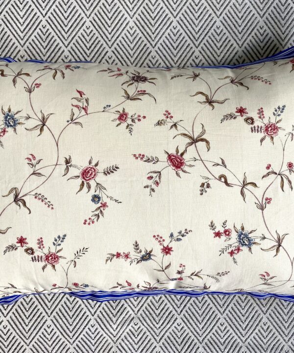 Floral sprig cushion in linen with blue striped trim.