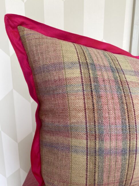 A pink tartan cushion (rose bud trellis design on the front).