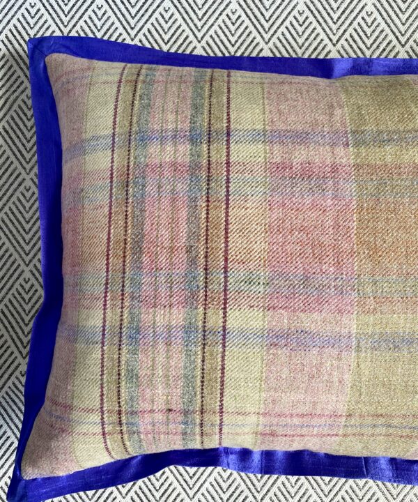 Detail of a tartan cushion reverse with a royal blue silk trim.