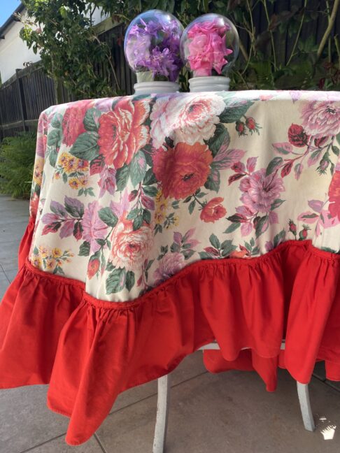 Floral tablecloth with a bold, red frill.