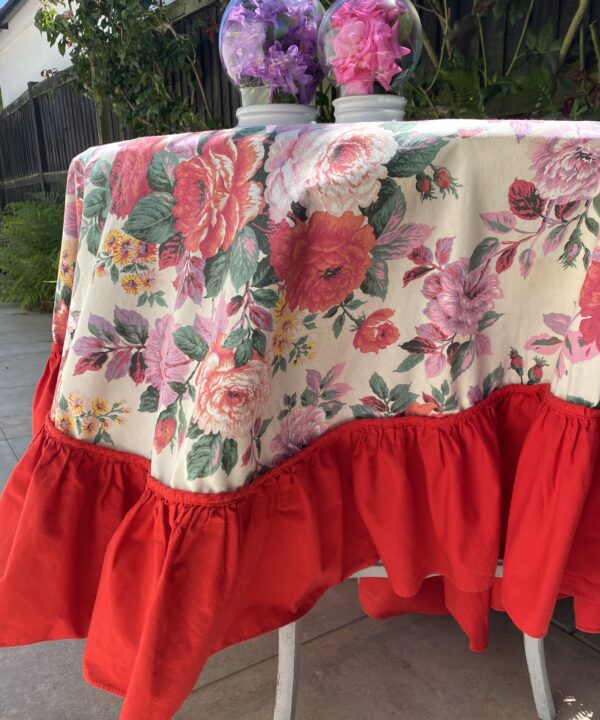 Floral tablecloth with a bold, red frill.