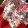 A vintage floral tablecloth with a bold, red frill.