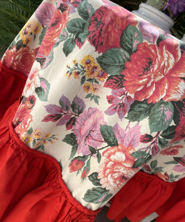 A vintage floral tablecloth with a bold, red frill.