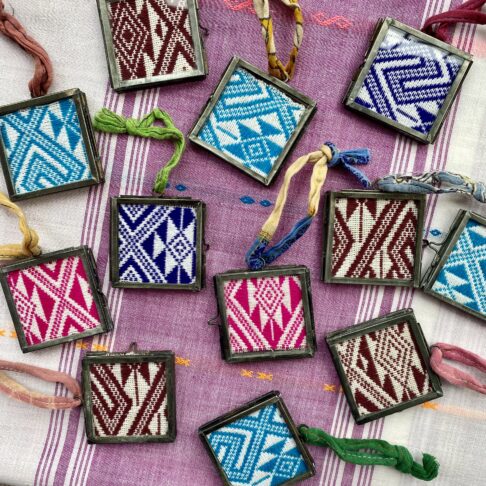 A colourful display of Thai textile remnants displayed in handmade metal and glass frames with vintage sari ties.