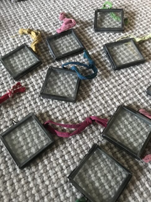 Miniature, hanging glass and metal photo frames.