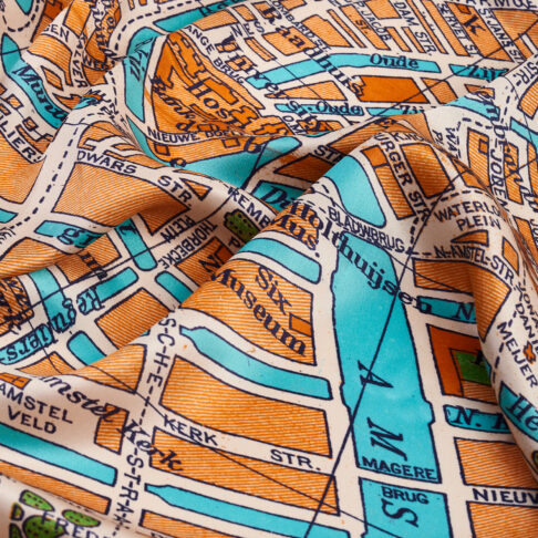 Detail of Amsterdam's city streets on an orange silk scarf printed with a vintage map of the city.