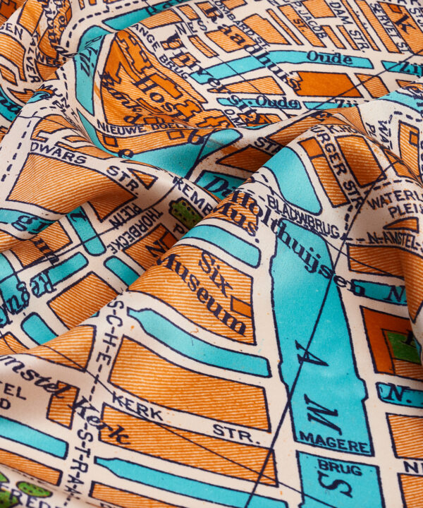 Detail of Amsterdam's city streets on an orange silk scarf printed with a vintage map of the city.