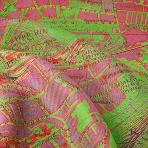 Close up detail of a pink and green silk scarf printed with a vintage map of the city of Edinburgh.