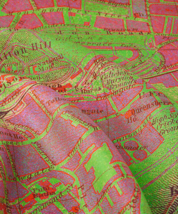 Close up detail of a pink and green silk scarf printed with a vintage map of the city of Edinburgh.