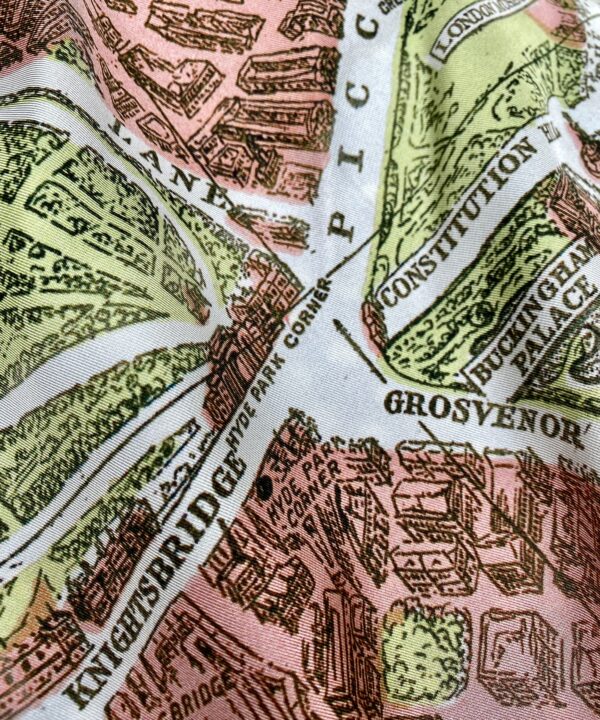 A salmon pink and pale green silk scarf depicting the city streets of London, England.