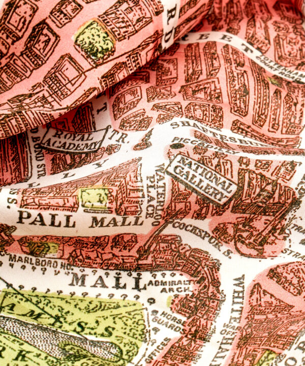 A detail of a pink silk scarf depicting a printed vintage map of London's streets.