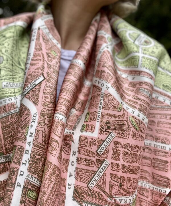 A model's shoulders are draped with this elegant pink silk scarf showcasing a vintage map of the London streets.