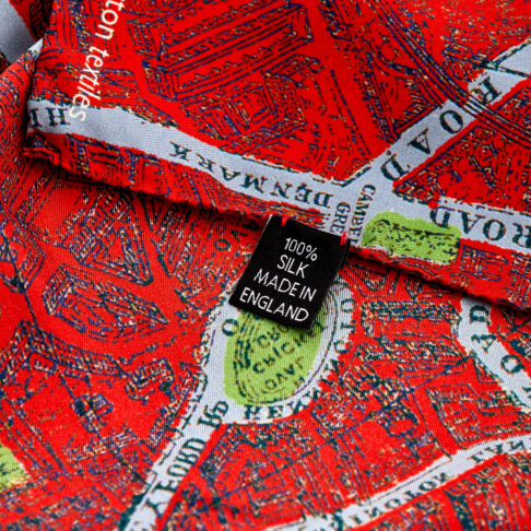 Detail of a bright red silk scarf with a London map print.