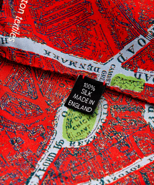 Detail of a bright red silk scarf with a London map print.