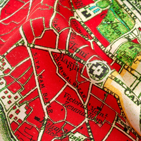 Close-up detail on a red silk scarf printed with a map of Delhi.