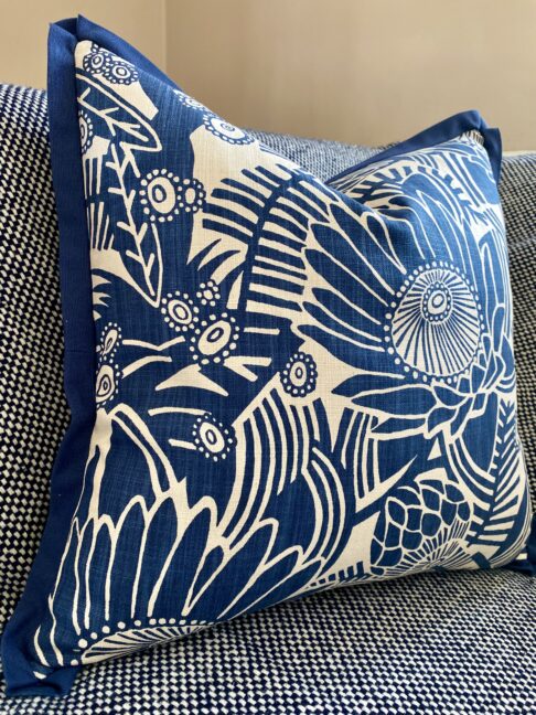 A blue floral cushion cover by Porcupine Rocks featuring a Protea print design.