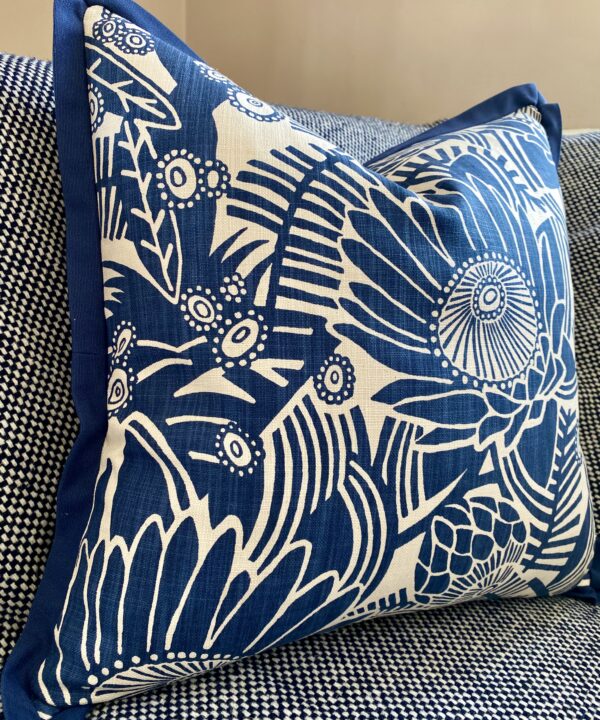 A blue floral cushion cover by Porcupine Rocks featuring a Protea print design.