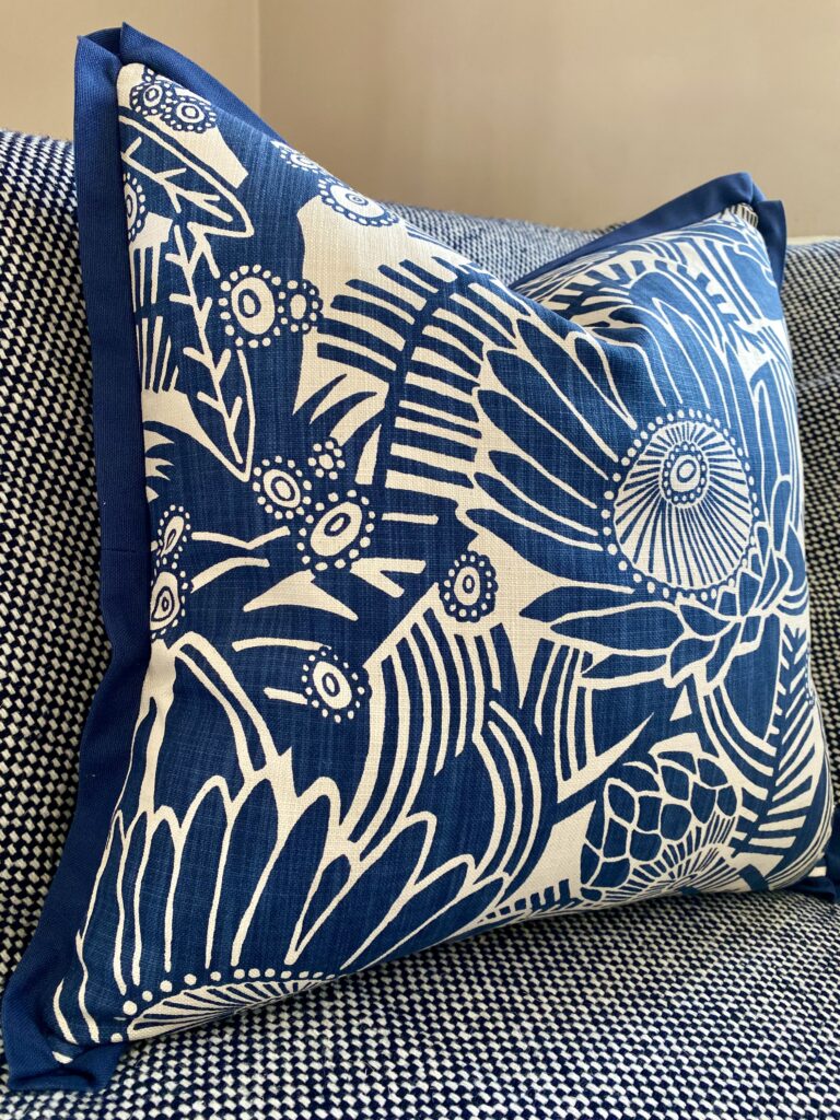 A blue floral cushion cover by Porcupine Rocks featuring a Protea print design.