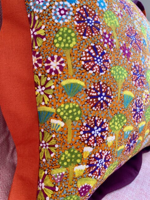 Close-up of floral Aboriginal art print on linen in bright and bold colours.