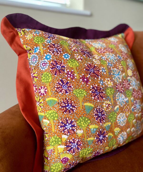 A brightly-coloured floral linen cushion in a pattern taken from an original indigenous Aboriginal art print.