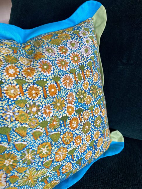 Bold yellow flowers on a cheerful indigenous Aboriginal art print cushion handmade in linen. Turquoise and green scalloped Oxford trim.