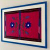 Blue framed embroidery art Mexican handmade textile shot from an angle.