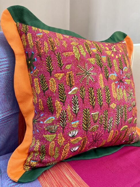 Boldly colourful multi-coloured cushions with a scalloped trim in pink, green and orange with an Aboriginal art printed on linen.