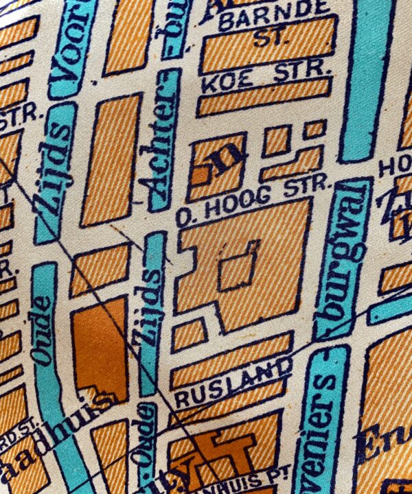 Detail of an orange silk scarf with turquoise accents depicting a vintage map of Amsterdam.