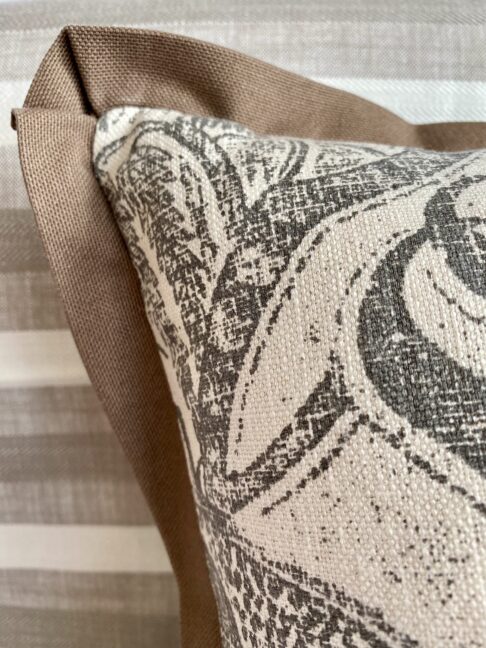 Detail of a taupe trim on a monochrome cushion cover.