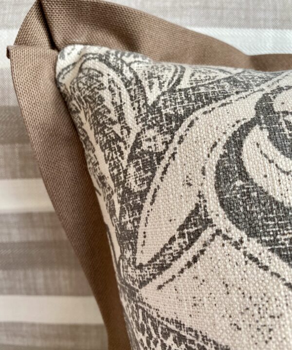 Detail of a taupe trim on a monochrome cushion cover.