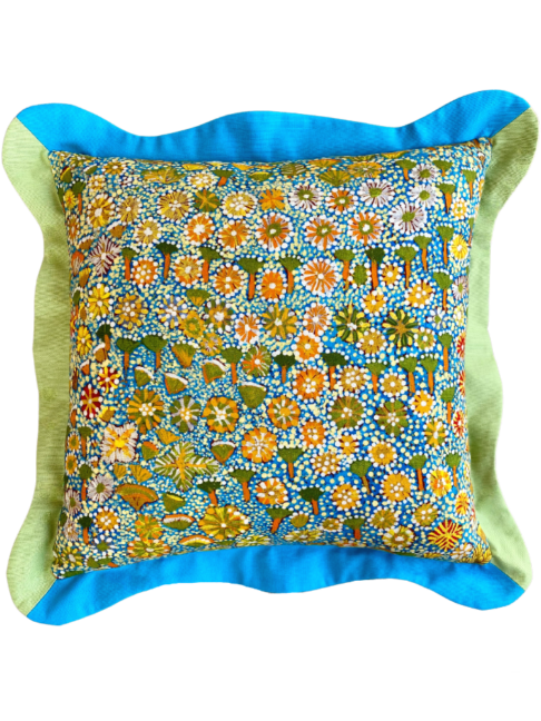 A multi-coloured cushion in blue and green depicting an Aboriginal art print on linen.