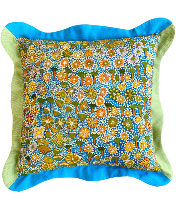 A multi-coloured cushion in blue and green depicting an Aboriginal art print on linen.