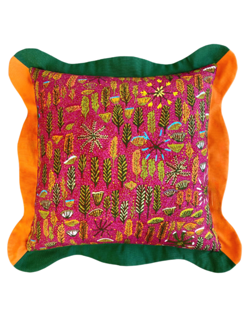 Multi-coloured cushions with a pink botanical print on linen and green and orange scalloped trim.
