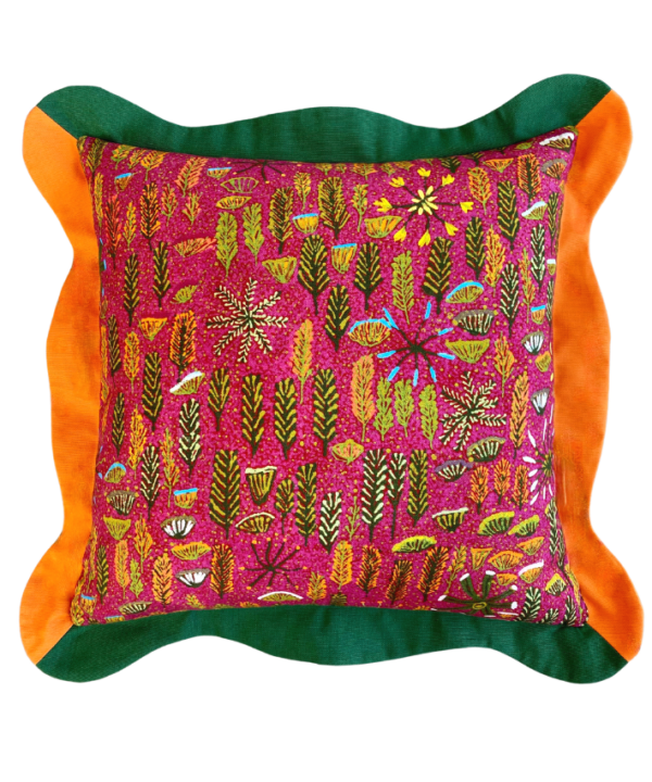 Multi-coloured cushions with a pink botanical print on linen and green and orange scalloped trim.