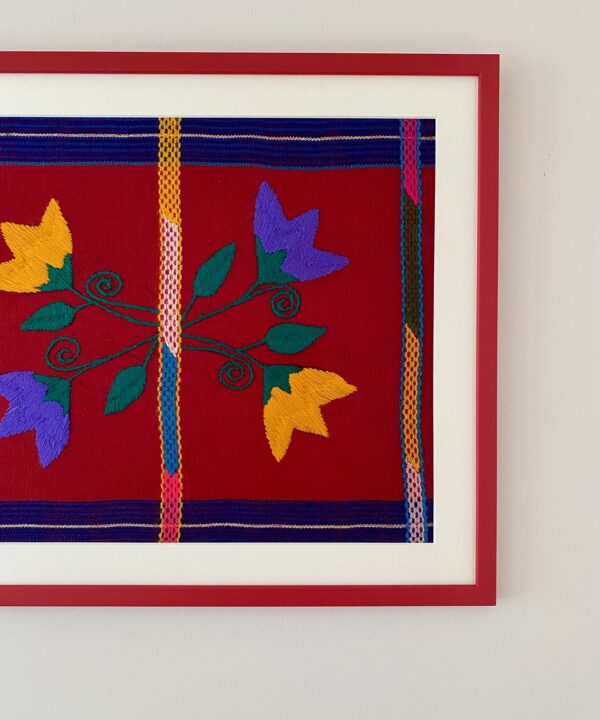 A red, yellow and violet Mexican textile embroidery framed in red.