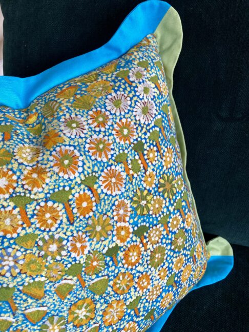 Brightly-coloured handmade linen and cotton cushion handmade using Aboriginal art print fabric.